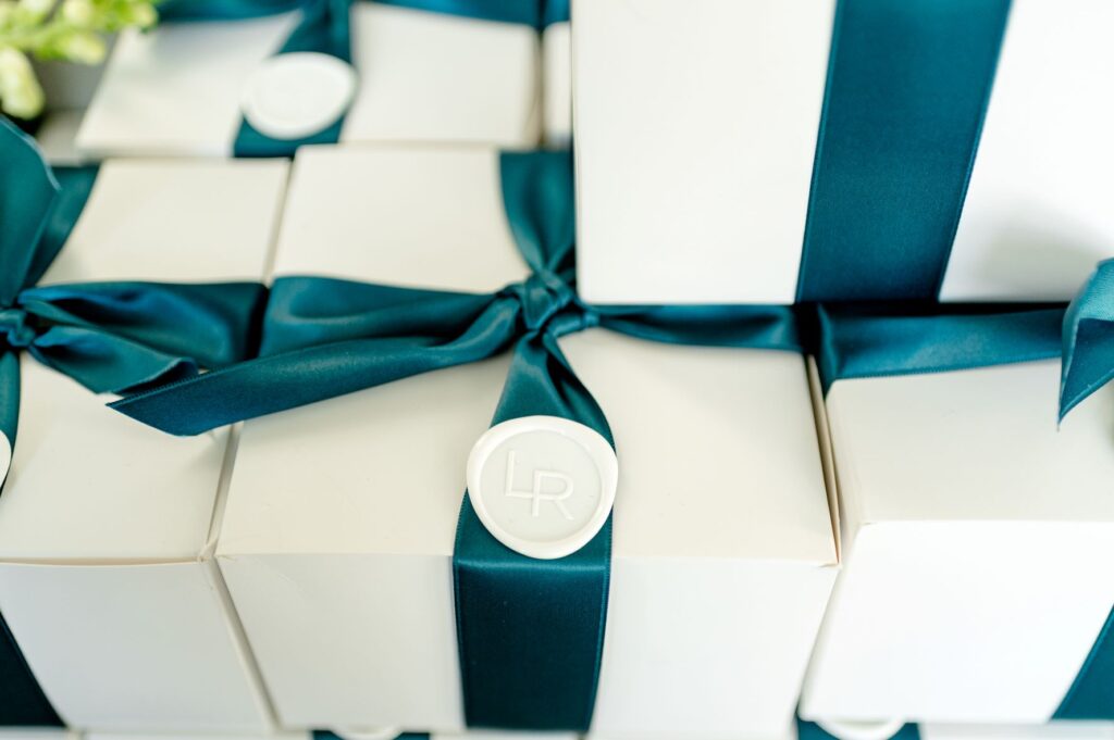 Gift boxes with teal ribbon and wax seal